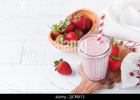 Smoothie aux fraises. Smoothie végétalien ou milkshake de fraise, banane et menthe sur fond blanc de table en bois. Manger propre, régime alcalin. Haut v Banque D'Images