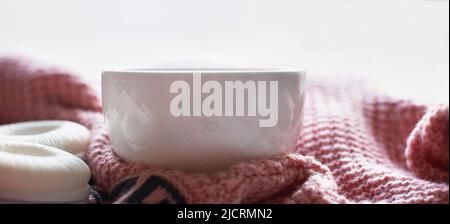 Agréable matin d'hiver à la maison. Thé ou café chaud, pull en maille et écouteurs près de la fenêtre. Concept de style de vie et de musique. Bannière Banque D'Images