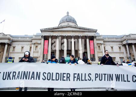 Les participants se réunissent au cours d’un stand avec l’Ukraine pour protester contre l’invasion de l’Ukraine par la Russie à Trafalgar Square à Londres. Banque D'Images