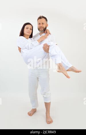 Photo verticale de couple homme et femme regarde la caméra. Un mode de vie sain. Homme tenir la femme dans les bras. Couple marié, amour Banque D'Images