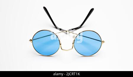 Lunettes de soleil avec lentille bleue et cadre métallique rond doré isolé sur fond blanc, lunettes de vacances d'été Banque D'Images