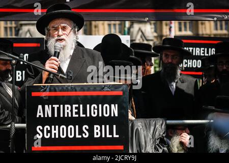 Londres, Royaume-Uni. 15th juin 2022. Asher Gratt, rabbin de Stamford Hill, parle. Une délégation de rabbies juifs, accompagnée de Haredi (9 membres orthodoxes de la communauté juive du Royaume-Uni), se sont réunis en dehors du Parlement pour protester contre le projet de loi sur les écoles 2022, qui passe par la Chambre des Lords. Le groupe considère le projet de loi sur les écoles comme une menace pour les aspects fondamentaux de la pratique juive et des principes religieux dans les écoles religieuses. Credit: Imagetraceur/Alamy Live News Banque D'Images