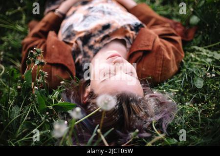 Jeune femme paisible couché sur l'herbe au printemps Banque D'Images