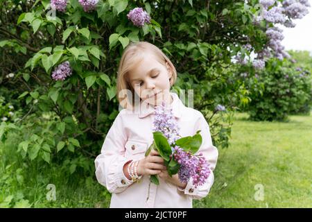 Portrait d'une fille dans un parc avec des lilas. Banque D'Images