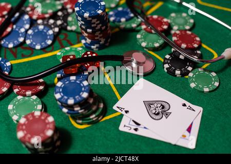 jetons de poker, argent, stéthoscope sur table de blackjack. Banque D'Images