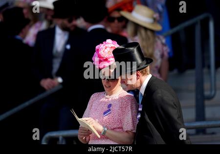 Les Racegoers étudient la carte de course avant le début de la dernière course du jour où le Palais de Kensington met en jeu pendant la deuxième journée de Royal Ascot à l'hippodrome d'Ascot. Date de la photo: Mercredi 15 juin 2022. Banque D'Images