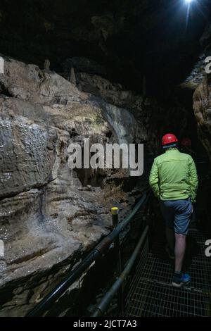 Visiteurs en casques de sécurité dans les superbes grottes de White SCAR à Ingleton, dans le North Yorkshire, en Angleterre. Banque D'Images