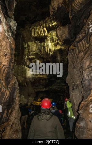 Visiteurs en casques de sécurité dans les superbes grottes de White SCAR à Ingleton, dans le North Yorkshire, en Angleterre. Banque D'Images