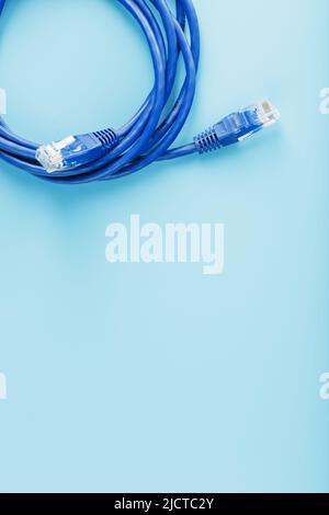 Une bobine de câble réseau Internet Ethernet RJ45 de catégorie 6 isolée sur fond bleu avec de l'espace libre Banque D'Images
