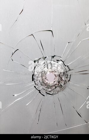 Trou de balle dans la roche. Fenêtre cassée, fissures. Banque D'Images