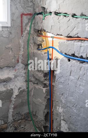 Rénovation et préparation de Communications dans l'appartement. Installation du système d'eau et du câblage électrique dans un mur en béton à l'aide d'une ondulée Banque D'Images