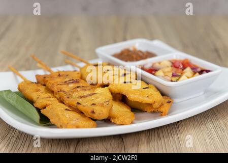 Poulet satay piquant sur des bâtonnets, servi avec de la salsa, sauce trempée et prêt à manger. Banque D'Images