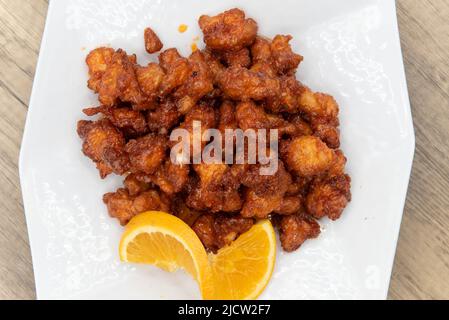 Vue en hauteur du poulet orange acidulé en morceaux croustillants et prêts à manger. Banque D'Images