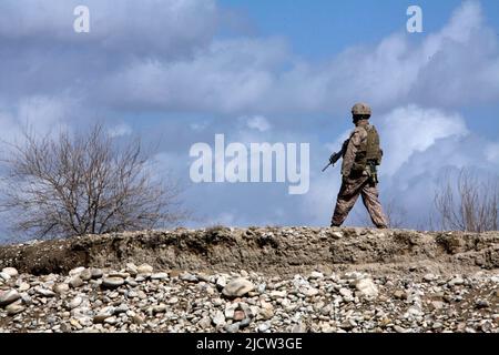 Une marine américaine avec 1st Bataillon, 8th Marine Regiment (1/8), équipe de combat régimentaire 6, patrouille dans un champ afghan à Kajaki, province de Helmond, Banque D'Images