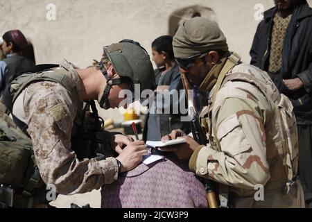 Caporal de lance du commando de la Marine royale britannique Alan Cahill (à gauche) écrit l'information d'un afghan pour traitement aux côtés d'un groupe de travail afghan (ATF Banque D'Images