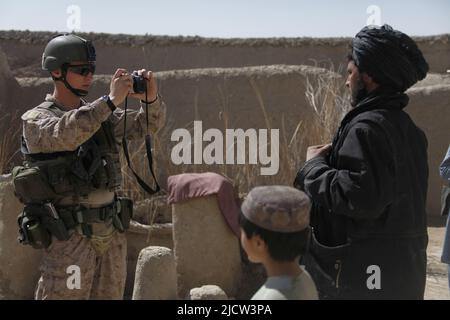 Caporal de lance du commando de la Marine royale britannique Alan Cahill (à gauche) photographie un afghan pour ses enregistrements à Kajaki, province de Helmond, Afghanistan 1 mars Banque D'Images