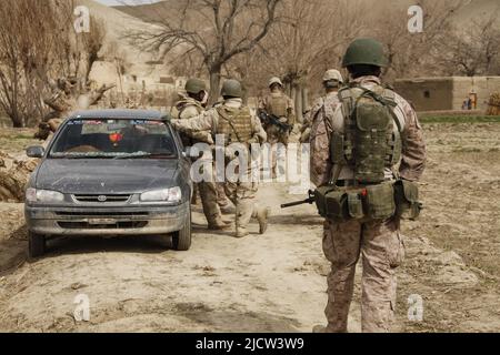 Une Marine royale britannique (à droite) se dirige vers un véhicule qui est recherché pour la contrebande par des soldats de la Force opérationnelle afghane (ATF) à Kajaki, à Helmond Banque D'Images