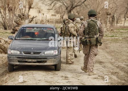 Une Marine royale britannique (à droite) se dirige vers un véhicule qui est recherché pour la contrebande par des soldats de la Force opérationnelle afghane (ATF) à Kajaki, à Helmond Banque D'Images