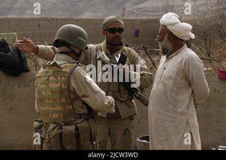 Les soldats de la Force opérationnelle afghane (ATF) interrogez l'aîné du village des régions locales au sujet de l'activité des Taliban à Kajaki, province de Helmond, 2 mars 2012 d'Afghanistan. Banque D'Images