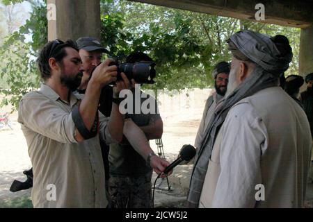 Ben Foley, à gauche, caméraman, et Bernard Smith, au centre, Journaliste, avec Al Jazeera English News Channel interview un professeur local d'école nationale afghane Banque D'Images