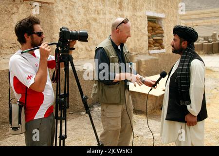 Bernard Smith, centre, journaliste, et Ben Foley, à gauche, Caméraman, avec Al Jazeera English News Channel interview un ressortissant afghan local à Kajaki, Hel Banque D'Images