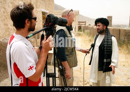 Bernard Smith, centre, journaliste, et Ben Foley, à gauche, Caméraman, avec Al Jazeera English News Channel interview un ressortissant afghan local à Kajaki, Hel Banque D'Images