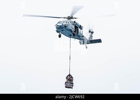 GOLFE D'ADEN (13 juin 2022) un hélicoptère MH-60s Sea Hawk affecté à l'escadron de combat de la mer des chevaliers de mer (HSC 22) transporte du fret au cours d'une reconstitution verticale avec le navire de combat littoral USS Sioux City (LCS 11), dans le golfe d'Aden (13 juin). Sioux City est déployée dans la zone d'opérations de la flotte américaine 5th afin d'assurer la sécurité et la stabilité maritimes dans la région du Moyen-Orient. (É.-U. Photo de la marine par le spécialiste des communications de masse 3rd classe Nicholas A. Russell) Banque D'Images