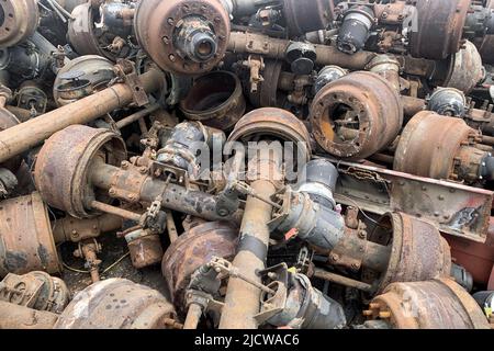 Pile d'un ancien essieu de camion rouillé pour la réutilisation, pièce d'automobile utilisée à la vente, ancien différentiel arrière de camion, essieu arrière de voiture sur chantier de ferraille Banque D'Images