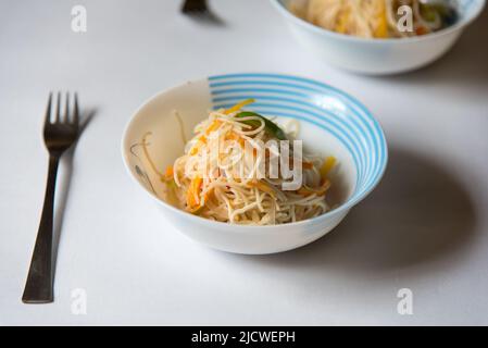 Nouilles prêtes à manger servies dans un bol sur fond. Vue de dessus, mise au point sélective. Banque D'Images