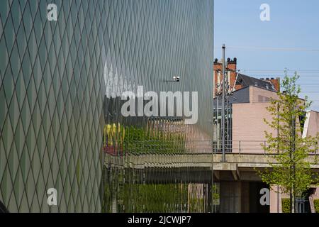 Reflet d'un train de banlieue en mouvement dans la façade vitrée du Futurium Berlin. Banque D'Images