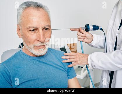 Un homme âgé se fait passer un examen de l'oreille à la clinique ORL avec un otolaryngologiste utilisant un endoscope vidéo. Endoscopie de l'oreille Banque D'Images