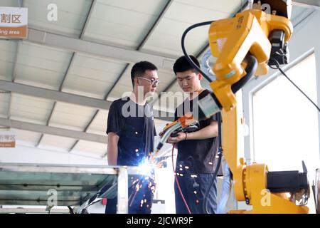 BINZHOU, CHINE - 16 JUIN 2022 - deux techniciens déboguent un produit commandé d'un nouveau robot industriel à Black Dot Electronics Technology Banque D'Images