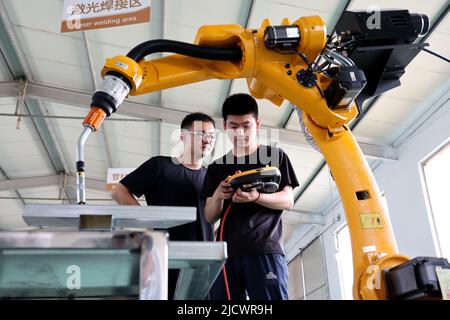 BINZHOU, CHINE - 16 JUIN 2022 - deux techniciens déboguent un produit commandé d'un nouveau robot industriel à Black Dot Electronics Technology Banque D'Images