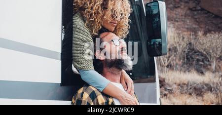 Voyagez avec le concept de style de vie de véhicule avec un couple heureux amoureux se hembrassant à destination. Femme embrasse l'homme avec la barbe. La nature en arrière-plan. Van Camper véh Banque D'Images