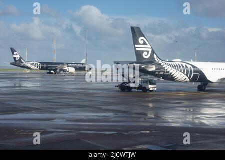 Auckland Nouvelle-Zélande - 13 juin 2022 : blanc et noir avions d'Air Nouvelle-zélande garés sur le tarmac. À l'aéroport d'Auckland après la pluie. Banque D'Images