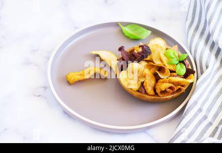 Bol de croustilles de légumes saines provenant de betteraves, de patates douces, de pommes, d'oranges et de carottes Banque D'Images