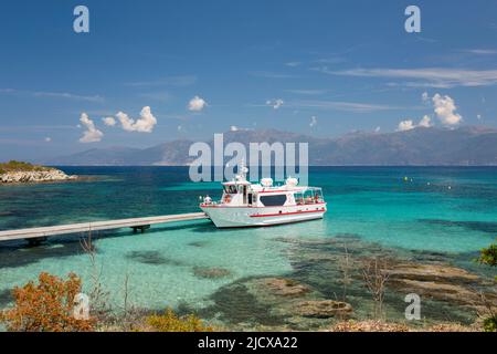 Bateau d'excursion amarré à la jetée dans des eaux turquoise claires au large de la Plage du Loto, St-Florent, haute-Corse, Corse, France, Méditerranée, Europe Banque D'Images