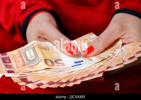 Mains de femmes détenant des billets en monnaie euro. Paiement et argent liquide et argent illégal et cupidité concept, France, Europe Banque D'Images