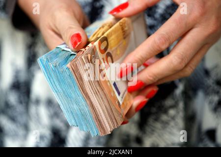 Femme détenant des billets en euros, concept de vol d'espèces, de riches, d'épargne ou de dépenser de l'argent, compte à rebours des paiements, France, Europe Banque D'Images