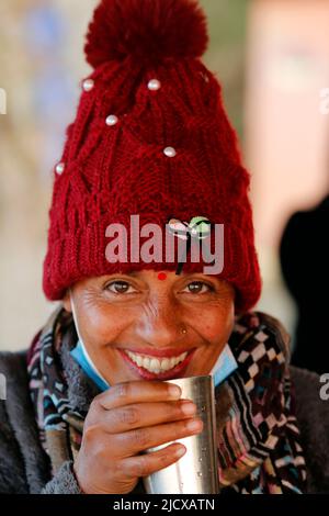 Portrait souriant d'une femme qui boit du thé, Népal, Asie Banque D'Images