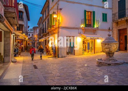 Vue sur les commerces dans la rue étroite dans la vieille ville de Pollenca au crépuscule, Pollenca, Majorque, Iles Baléares, Espagne, Méditerranée, Europe Banque D'Images