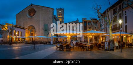 Vue sur l'église Santa Maria et les gens à l'extérieur du bar à Placa Mayor dans la vieille ville de Pollenca au crépuscule, Pollenca, Majorque, Iles Baléares, Espagne Banque D'Images