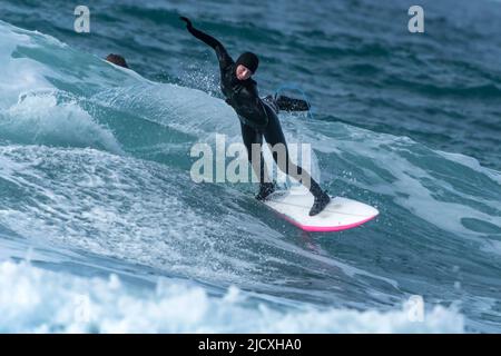 Un surfeur qui profite d'une spectaculaire action de surf en hiver à Fistral à Newquay, en Cornouailles, au Royaume-Uni. Banque D'Images