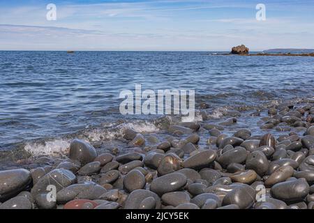 Vue panoramique sur la mer de Greencliff Beach, avec Wet Pebbles, Exposed Rocks et vue côtière vers Croyde à Mid Tide: Greencliff, près de Bideford Banque D'Images