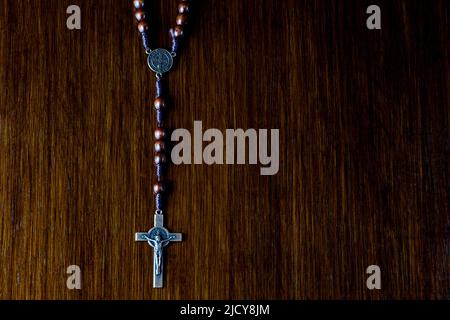 Perles de crucifix et de rosaire sur un arrière-plan en bois poli ancien Banque D'Images