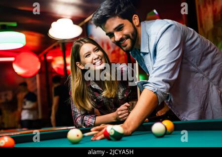 Un jeune couple heureux s'amuser en jouant au billard au bar. Concept de divertissement pour les personnes Banque D'Images