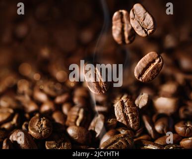 Grains de café torréfiés bruns gros plan sur fond sombre Banque D'Images