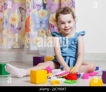 belle fille joue des jouets dans la chambre Banque D'Images