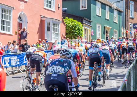 Les coureurs qui s'affrontant à Market Hill à Maldon lors de la course cycliste RideLondon Classique UCI Women's WorldTour 2022. Maisons et spectateurs locaux Banque D'Images