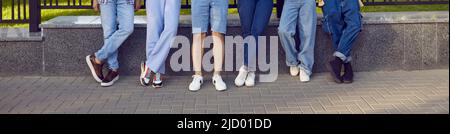 Groupe de personnes portant des jeans, des pantalons décontractés, des shorts et des baskets debout sur la rue de la ville Banque D'Images